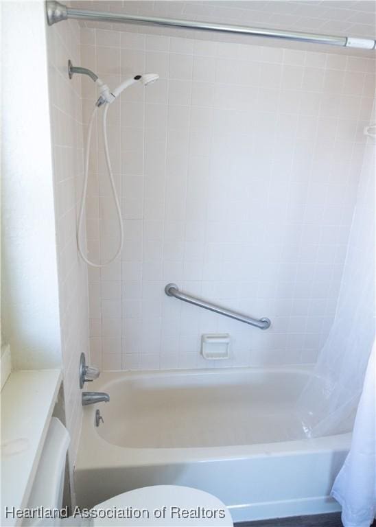 bathroom with toilet and shower / bathtub combination with curtain