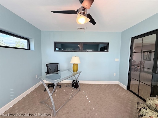 home office featuring carpet floors, baseboards, visible vents, and a ceiling fan