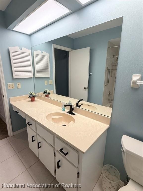 full bath with a skylight, toilet, shower / tub combination, tile patterned flooring, and vanity