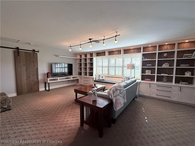 living room featuring a barn door, track lighting, dark carpet, and baseboards