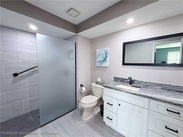 bathroom with toilet, walk in shower, and vanity