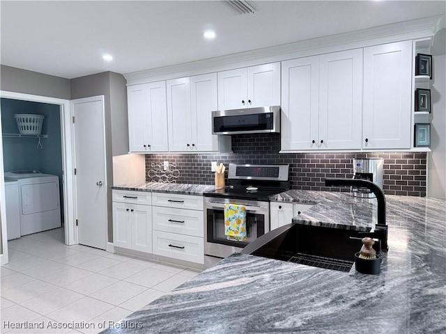 kitchen featuring appliances with stainless steel finishes, white cabinets, and dark stone countertops