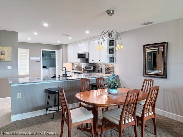 dining room with recessed lighting, baseboards, visible vents, and independent washer and dryer