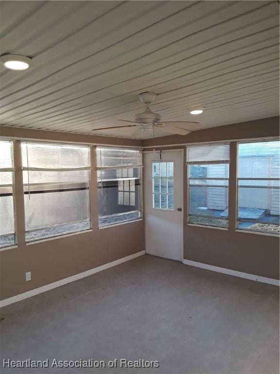 unfurnished sunroom with ceiling fan and wooden ceiling