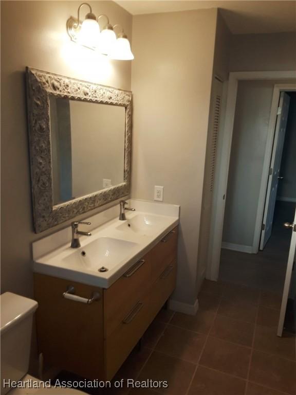 bathroom featuring vanity, tile patterned floors, and toilet