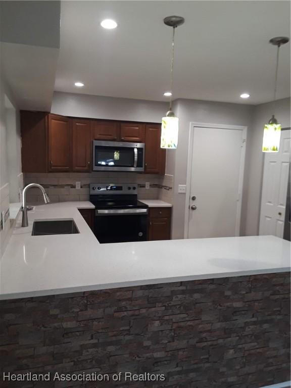 kitchen featuring black range with electric stovetop, decorative light fixtures, sink, and backsplash