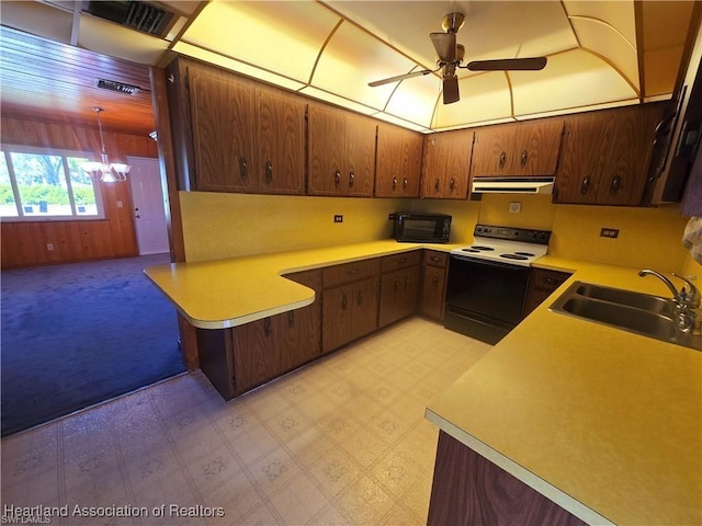 kitchen with ceiling fan with notable chandelier, pendant lighting, white electric stove, sink, and kitchen peninsula