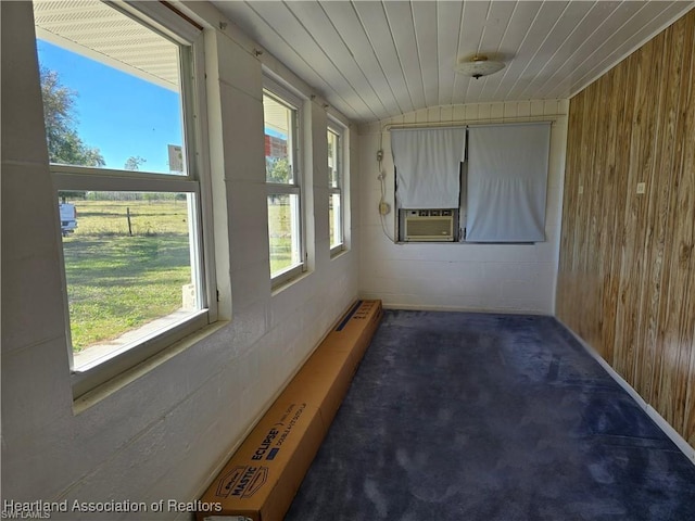 unfurnished sunroom featuring cooling unit, lofted ceiling, a wealth of natural light, and wooden ceiling