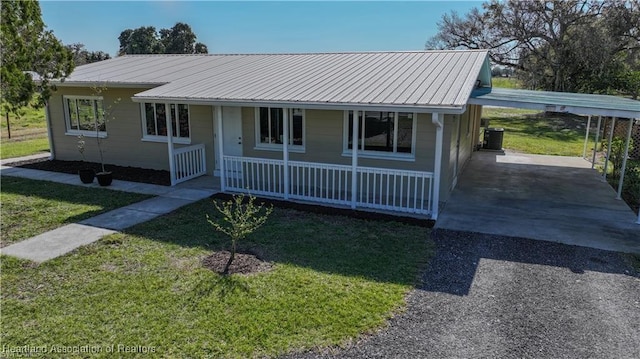 view of front of home featuring central AC, a front yard, a carport, and a porch