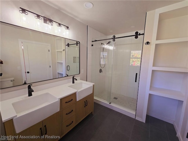 bathroom with vanity, toilet, tile patterned floors, and a shower with shower door