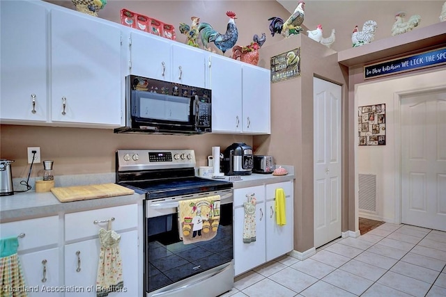 kitchen featuring light tile patterned floors, white cabinets, and stainless steel electric range oven