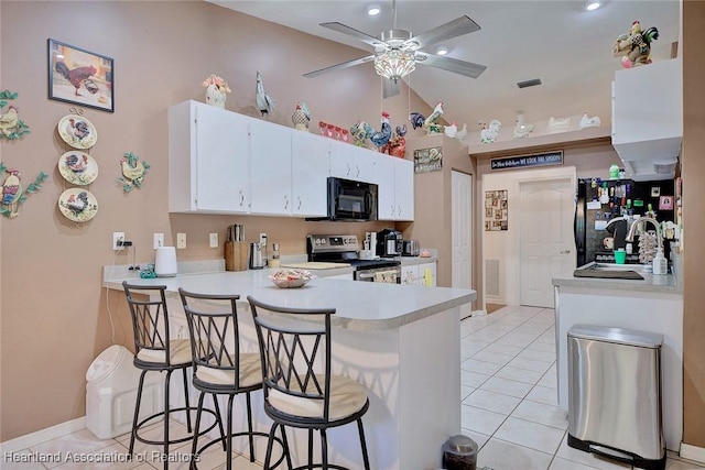 kitchen featuring a breakfast bar, stainless steel range with electric stovetop, white cabinetry, light tile patterned flooring, and kitchen peninsula