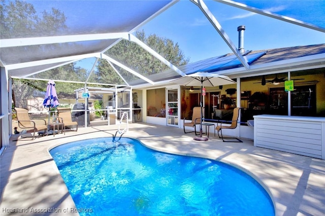 view of pool featuring ceiling fan, a lanai, and a patio area