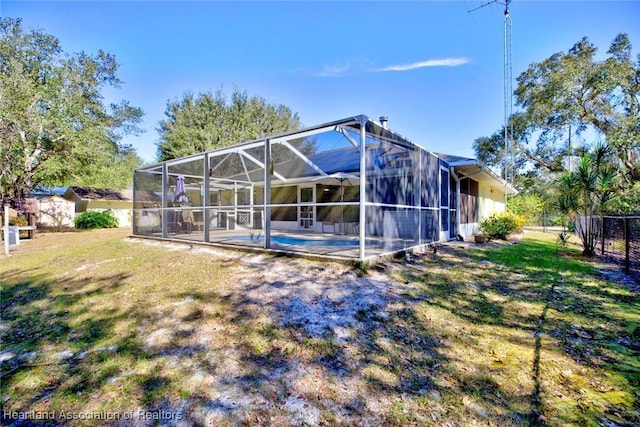 rear view of property featuring a swimming pool, a storage shed, a lanai, a yard, and a patio area