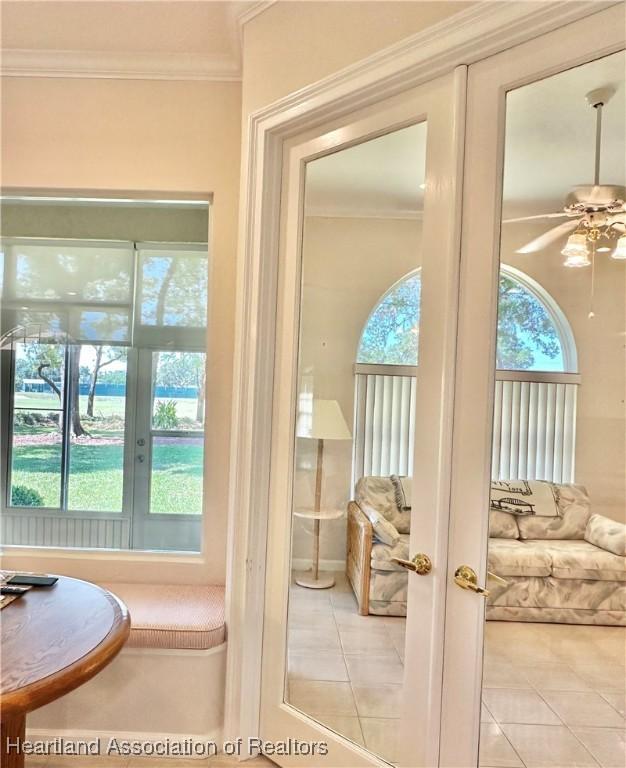 doorway to outside featuring tile patterned floors, french doors, ceiling fan, and a healthy amount of sunlight