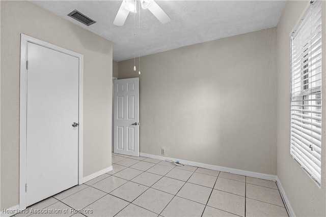 1108 Edgemoor Ave, Sebring, FL 33870 - unfurnished bedroom with multiple windows, light tile patterned flooring, and ceiling fan