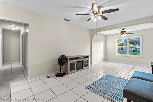 1108 Edgemoor Ave, Sebring, FL 33870 - unfurnished living room with a textured ceiling, light tile patterned floors, and ceiling fan