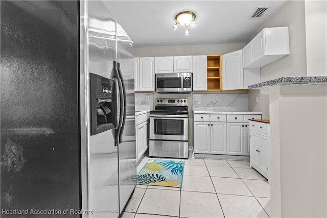 1108 Edgemoor Ave, Sebring, FL 33870 - kitchen with stainless steel appliances, white cabinets, light tile patterned floors, and light countertops