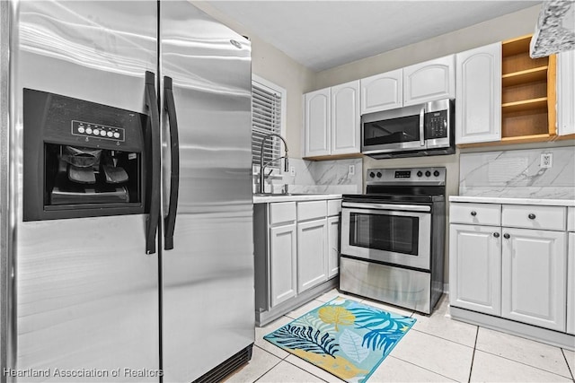 1108 Edgemoor Ave, Sebring, FL 33870 - kitchen featuring stainless steel appliances, white cabinetry, light countertops, open shelves, and light tile patterned flooring