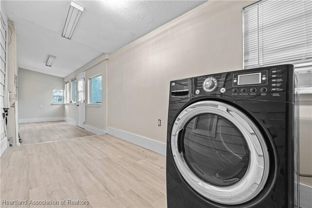 1108 Edgemoor Ave, Sebring, FL 33870 - laundry area featuring washer / dryer, wood finished floors, and a textured ceiling