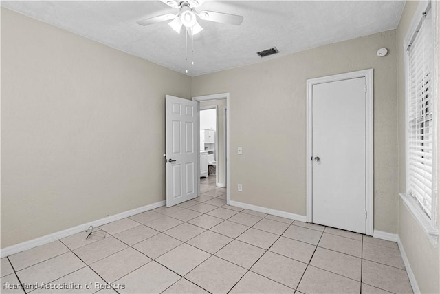 1108 Edgemoor Ave, Sebring, FL 33870 - unfurnished bedroom with light tile patterned floors, a textured ceiling, and a ceiling fan