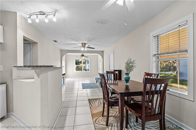 1108 Edgemoor Ave, Sebring, FL 33870 - dining room featuring a ceiling fan, arched walkways, light tile patterned floors, and a textured ceiling