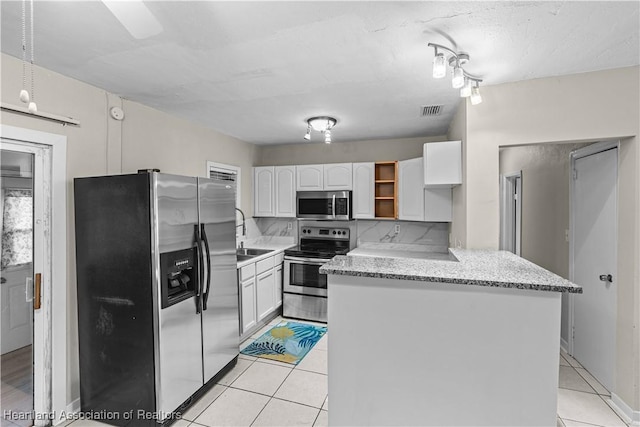 1108 Edgemoor Ave, Sebring, FL 33870 - kitchen with appliances with stainless steel finishes, white cabinets, light tile patterned floors, open shelves, and light stone counters