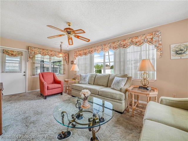 carpeted living area featuring ceiling fan and a textured ceiling