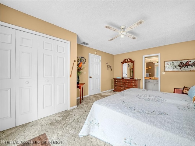 bedroom featuring a textured ceiling, ceiling fan, light colored carpet, visible vents, and a closet