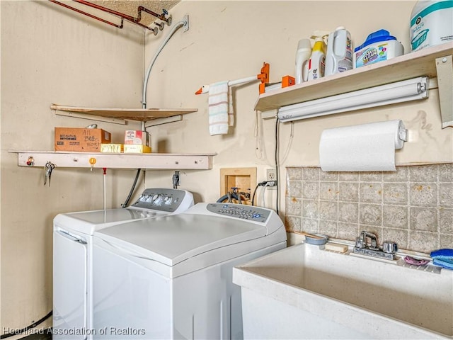 washroom with laundry area, a sink, and washer and dryer