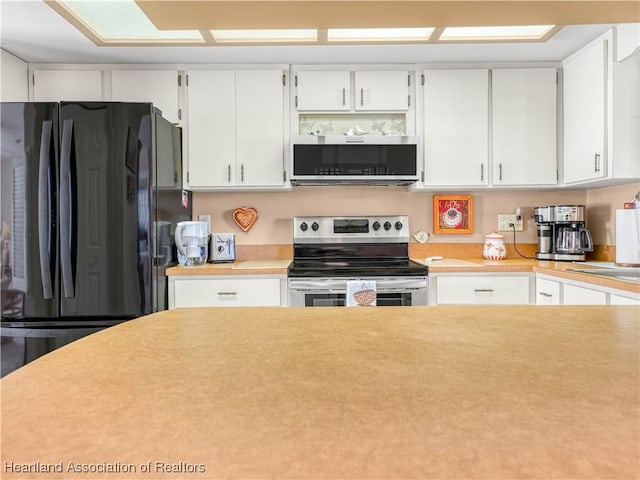 kitchen featuring appliances with stainless steel finishes, light countertops, and white cabinets