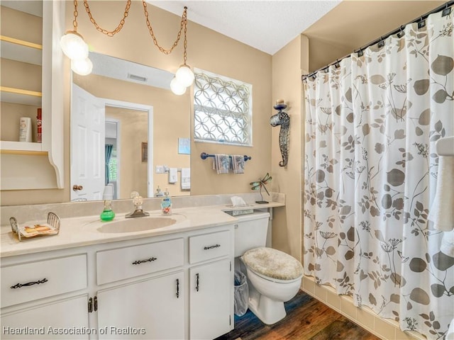 bathroom featuring a stall shower, visible vents, wood finished floors, and vanity