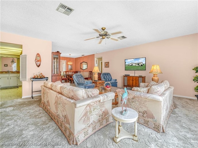 living room with visible vents, light carpet, and a textured ceiling