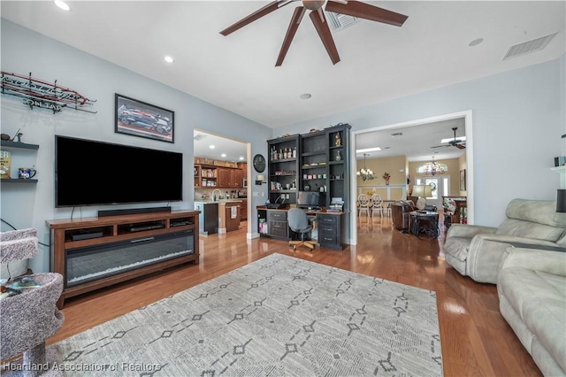 living room with hardwood / wood-style flooring, sink, and ceiling fan