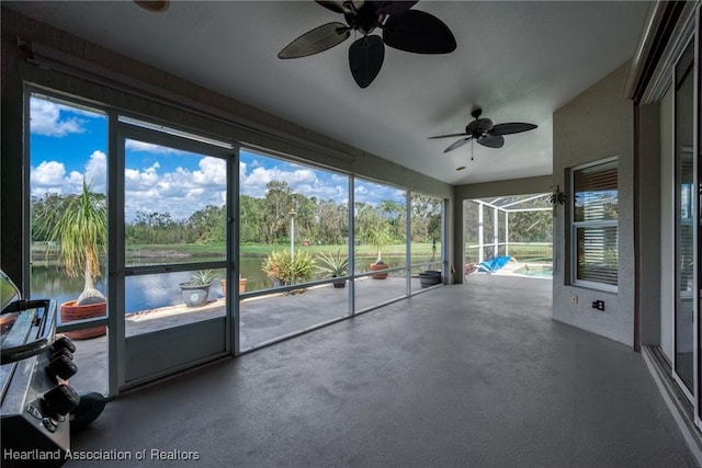 unfurnished sunroom with a water view and ceiling fan