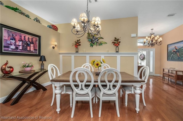 dining room with hardwood / wood-style floors and a chandelier