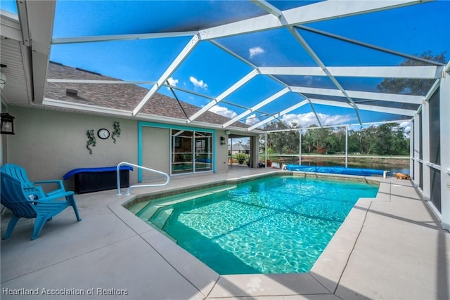 view of swimming pool featuring glass enclosure and a patio area