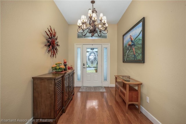 entrance foyer with wood-type flooring and a notable chandelier