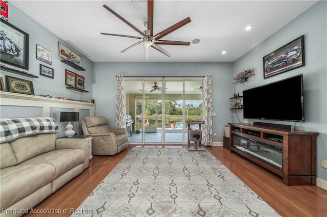 living room featuring wood-type flooring and ceiling fan