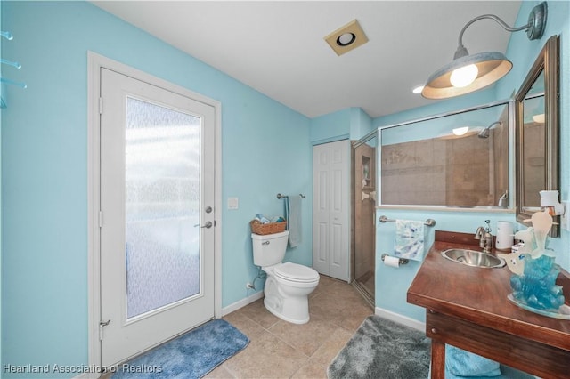 bathroom with vanity, tile patterned flooring, a shower with door, and toilet