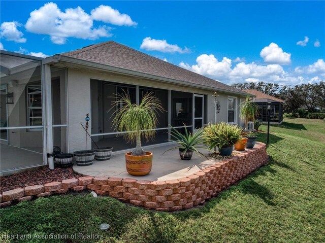 rear view of house with a lawn and a patio