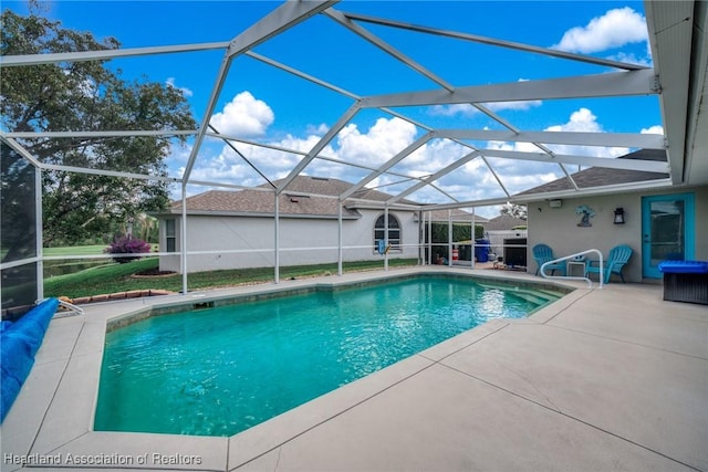 view of swimming pool featuring a patio and glass enclosure