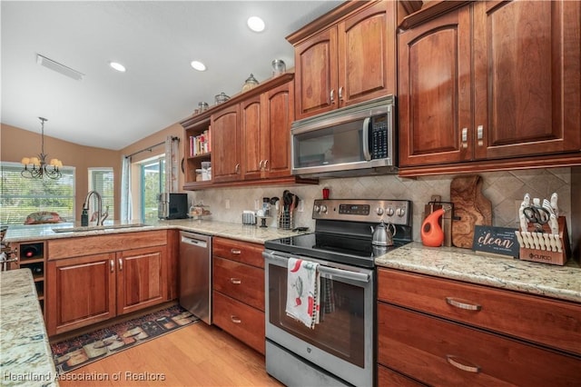 kitchen with sink, tasteful backsplash, light hardwood / wood-style flooring, stainless steel appliances, and light stone countertops