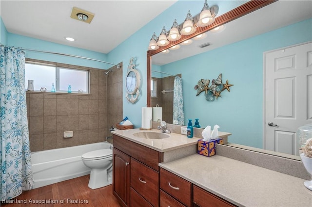 full bathroom featuring wood-type flooring, shower / bathtub combination with curtain, vanity, and toilet