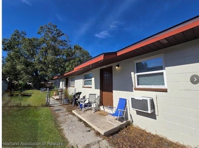 exterior space with a yard, a wall mounted air conditioner, and a patio area