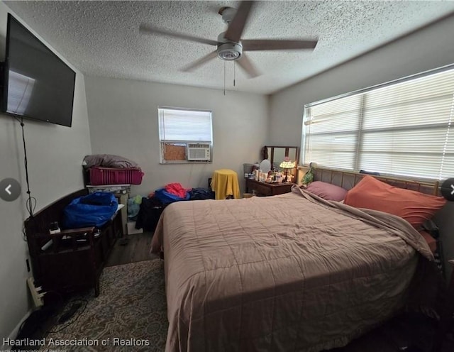 bedroom with hardwood / wood-style flooring, ceiling fan, and a textured ceiling