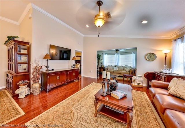 living room with wood-type flooring, lofted ceiling, and ornamental molding