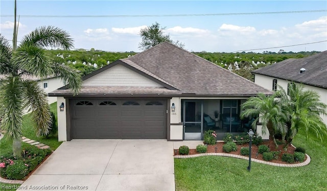 view of front facade featuring a garage, a front lawn, and a sunroom