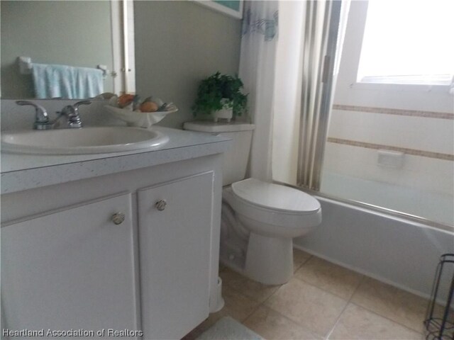 full bathroom with tile patterned flooring, shower / tub combo, vanity, and toilet