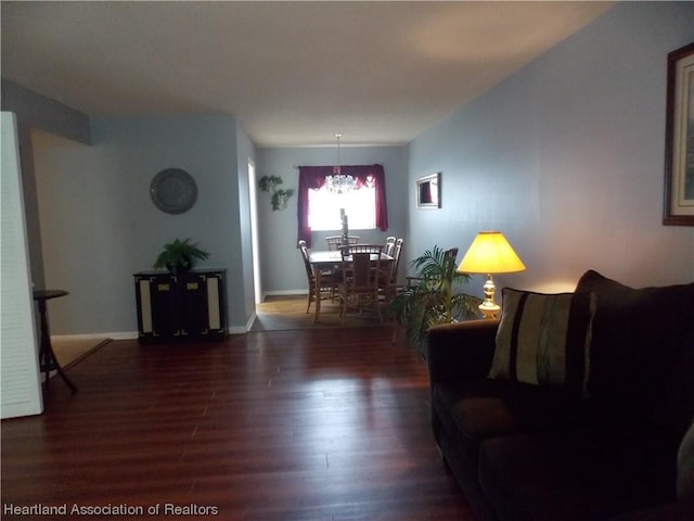 living room featuring a notable chandelier and dark hardwood / wood-style flooring